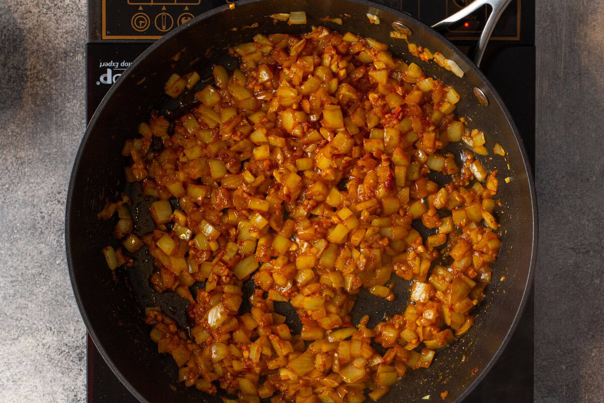 diced onions, curry, and other seasonings sauteed in skillet