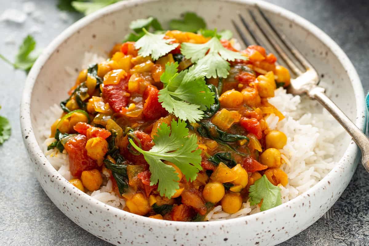 chickpea curry on top of rice in bowl
