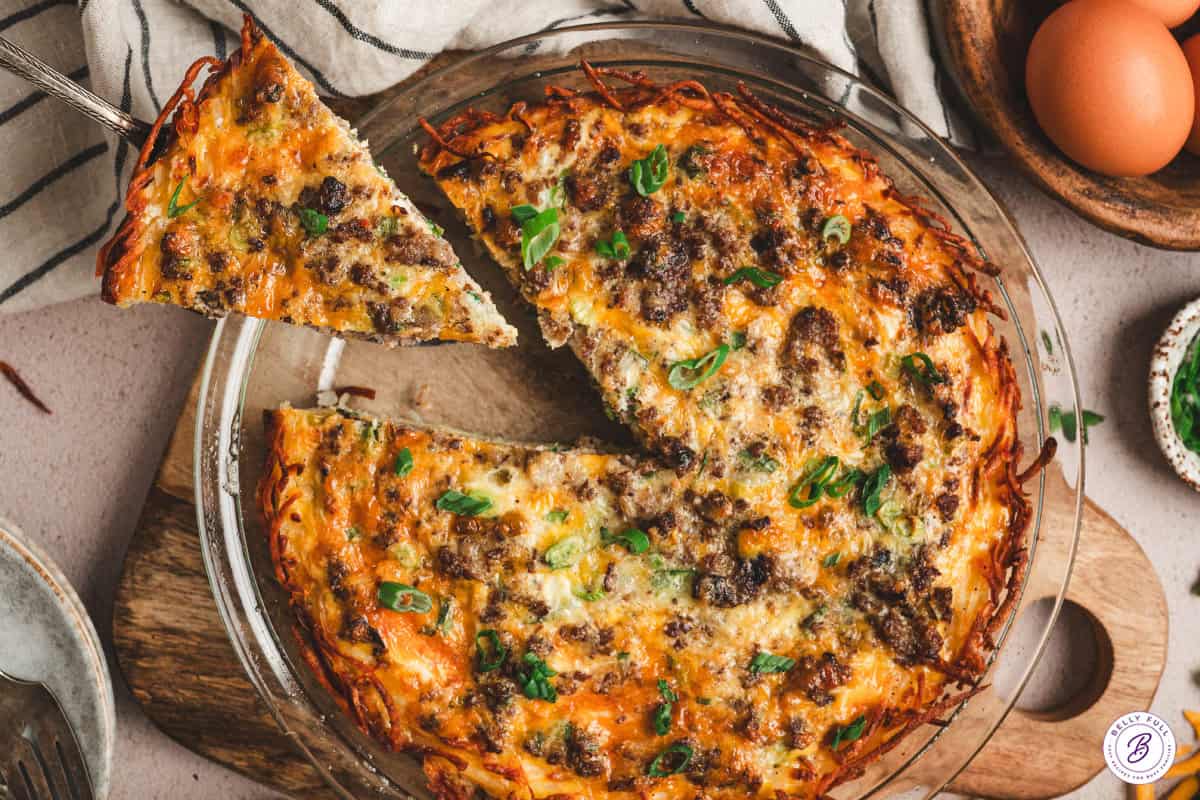 hash brown crusted quiche in pie plate with slice