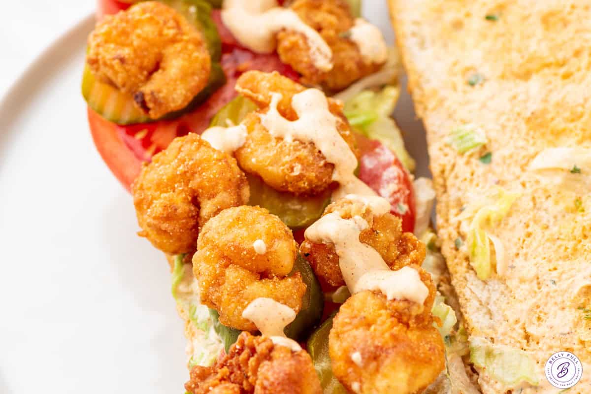 drizzle of Remoulade Sauce over shrimp po boy sandwich