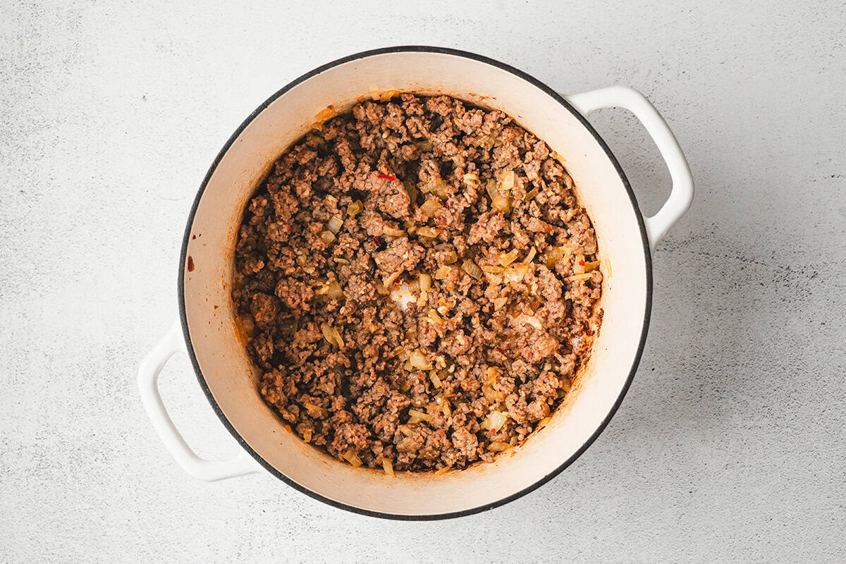 soup pot with sausage crumbles, onions, and seasonings