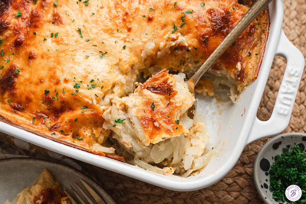 a spoon serving up a scoop of au gratin potatoes