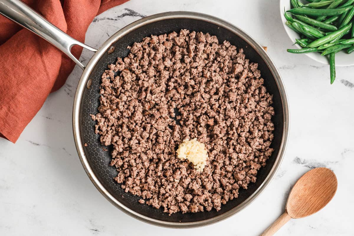 cooked ground beef crumbles and minced garlic in skillet
