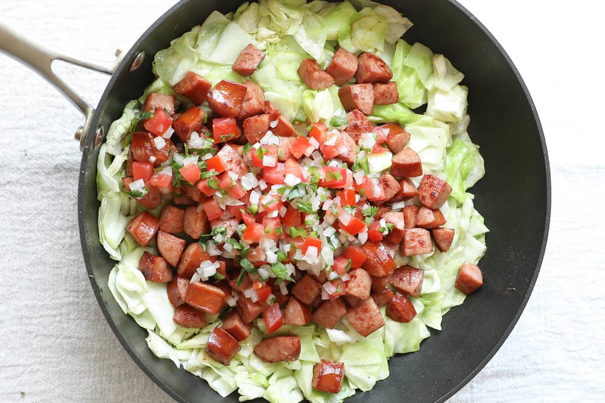 Cabbage, diced kielbasa, and pice de gallo in skillet