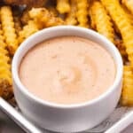 Side view of a bowl of raising cane's sauce.