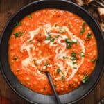 overhead bowl of tomato soup with drizzle of cream