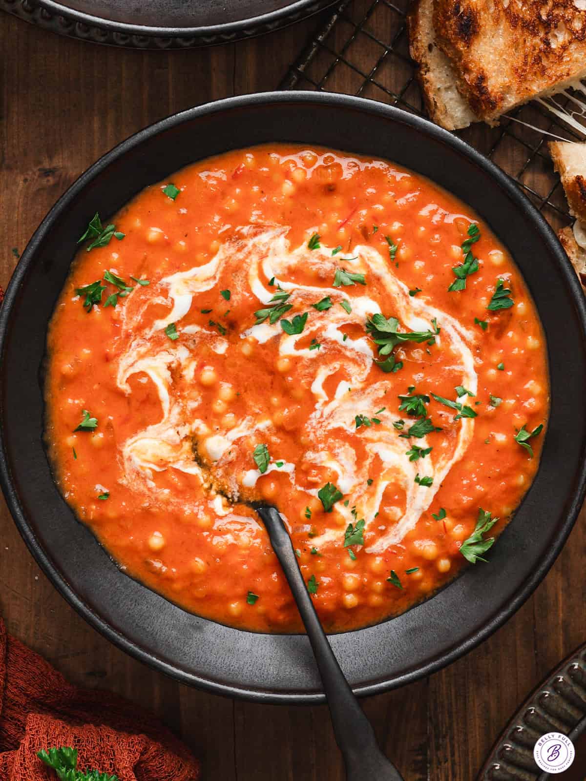 overhead bowl of tomato soup with drizzle of cream