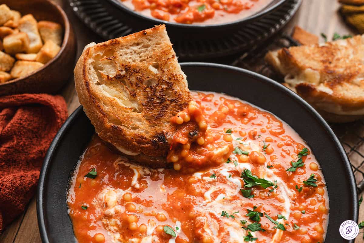 bowl of tomato soup with grilled cheese sandwich