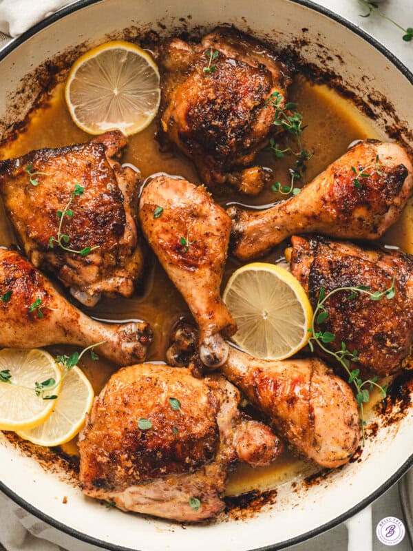 Balsamic lemon chicken thighs and drumsticks in a skillet with crispy lemon sugar skin, buttery pan sauce, lemon slices, and fresh thyme