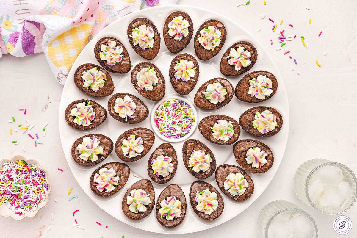 Deviled Brownies on a deviled egg tray that mimic classic savory deviled eggs with a brownie base and piped frosting
