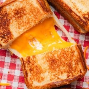 Overhead view of a copycat Disneyland grilled cheese sandwich sliced in half with melted cheese connecting the two halves.