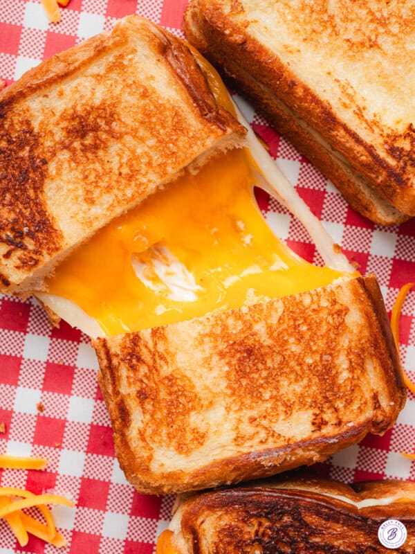 Overhead view of a copycat Disneyland grilled cheese sandwich sliced in half with melted cheese connecting the two halves.