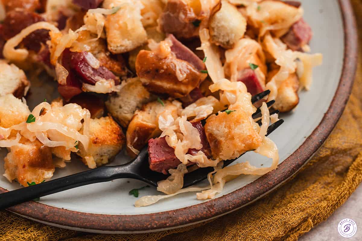 Close up view of a serving of reuben bake casserole on a plate.