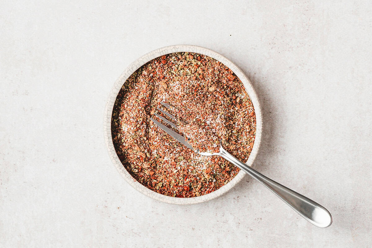 Bowl of homemade brisket spice rub with paprika, herbs, and seasonings mixed together