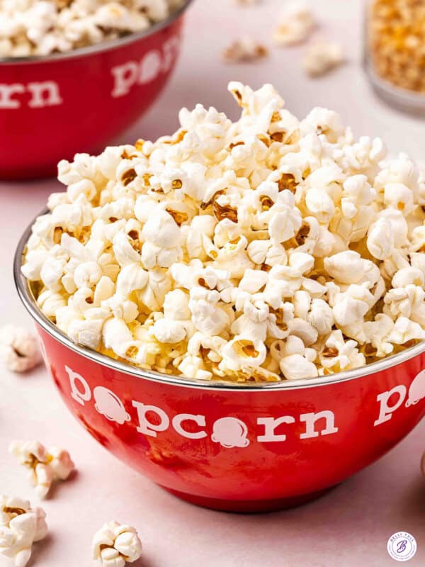 Stovetop popcorn piled high in a red popcorn bowl with fluffy freshly popped kernels.