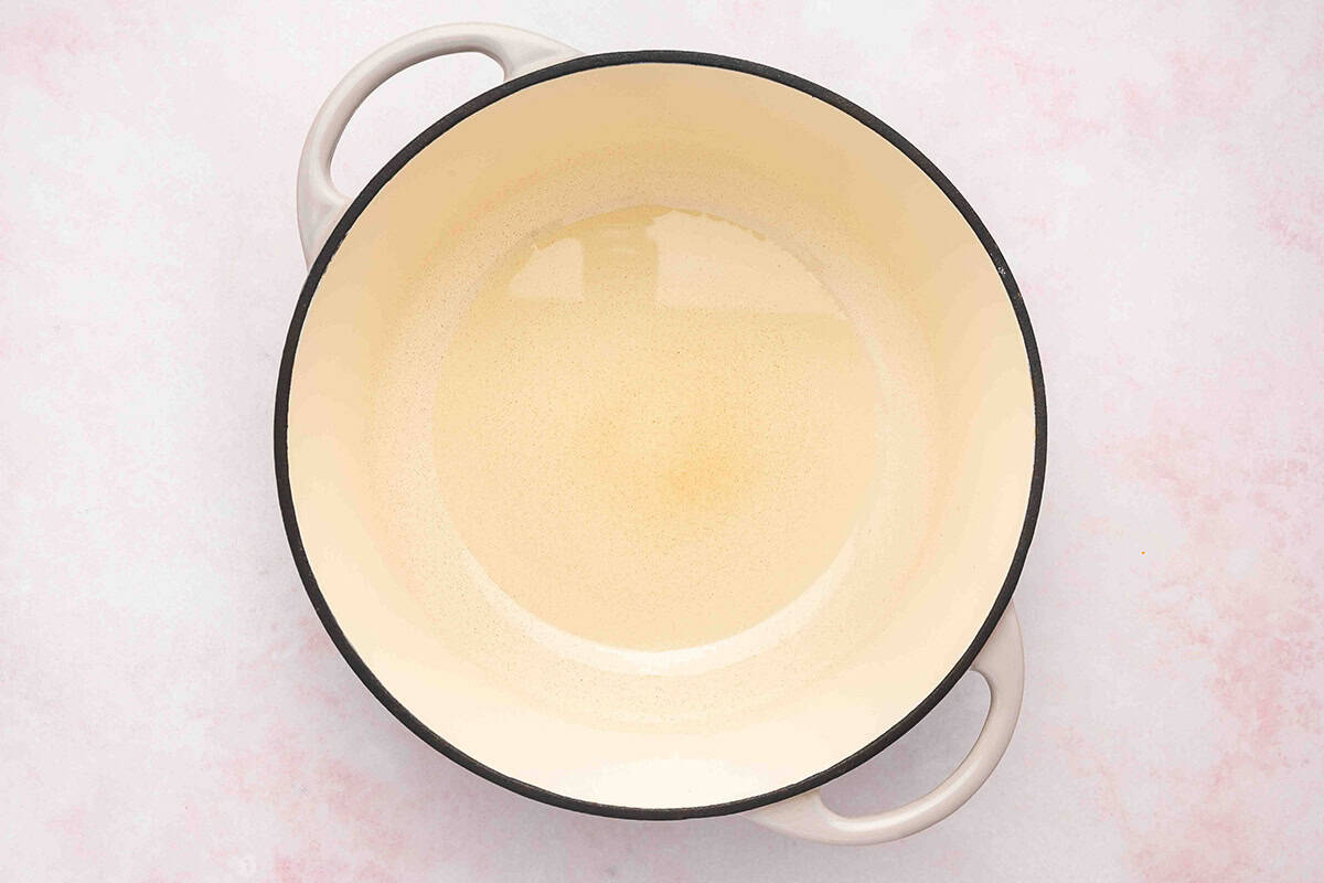 Vegetable oil heating in a heavy bottom pot for making stovetop popcorn.