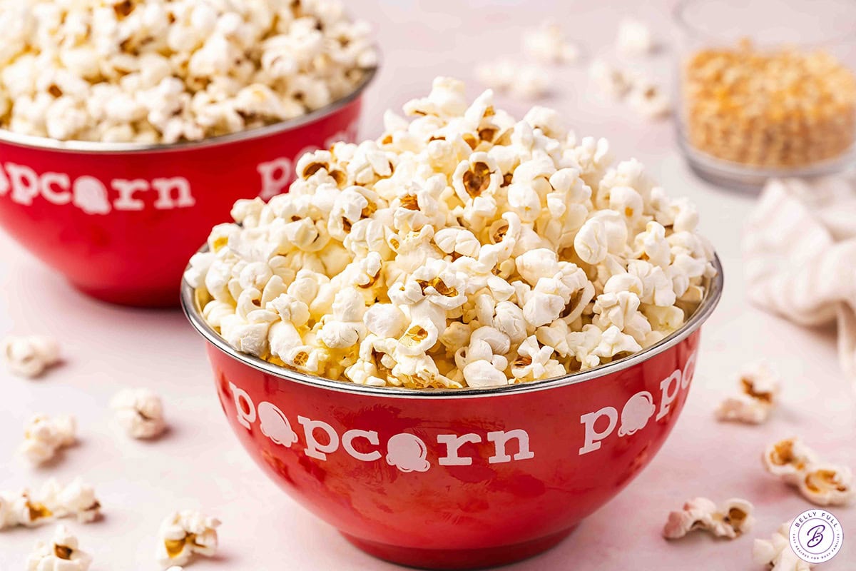 Fresh homemade stovetop popcorn served in a red popcorn bowl.