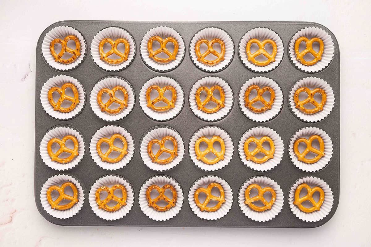 Pretzels in a mini muffin pan with muffin liners.