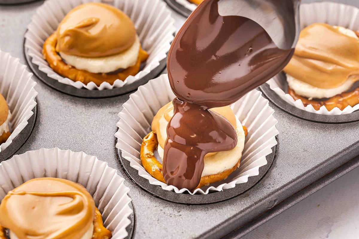 A spoon topping chocolate pretzel banana bites with melted chocolate.