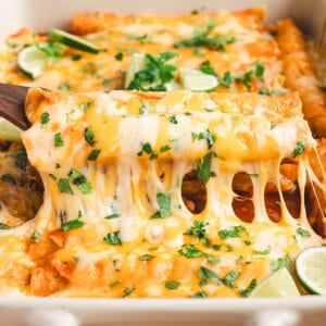 A spatula lifting lazy enchiladas out of a baking dish.