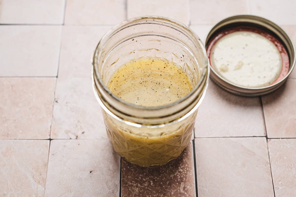A homemade maroulosalata dressing in a mason jar.