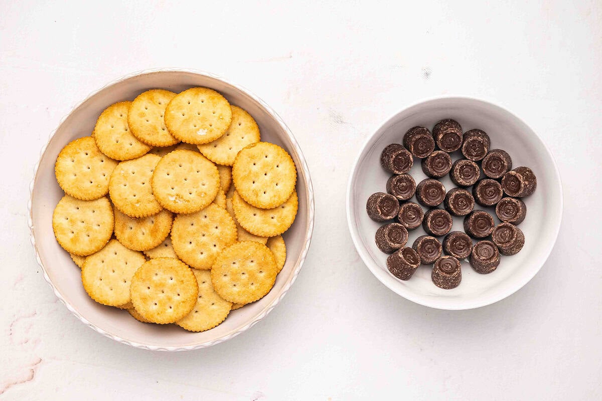 A bowl of ritz crackers and a bowl of rolo candies.