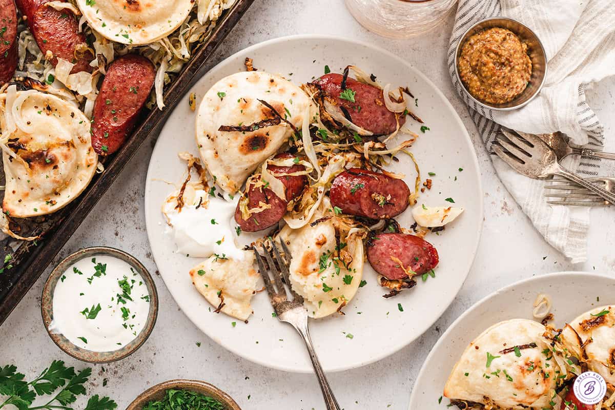 roasted Pierogi and Sausage on plate with sour cream
