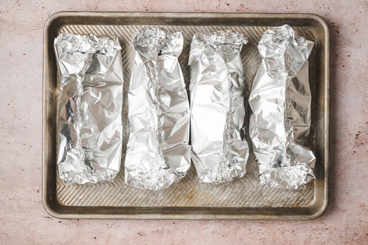 Four Southwestern Chicken Foil Packets on a baking sheet.
