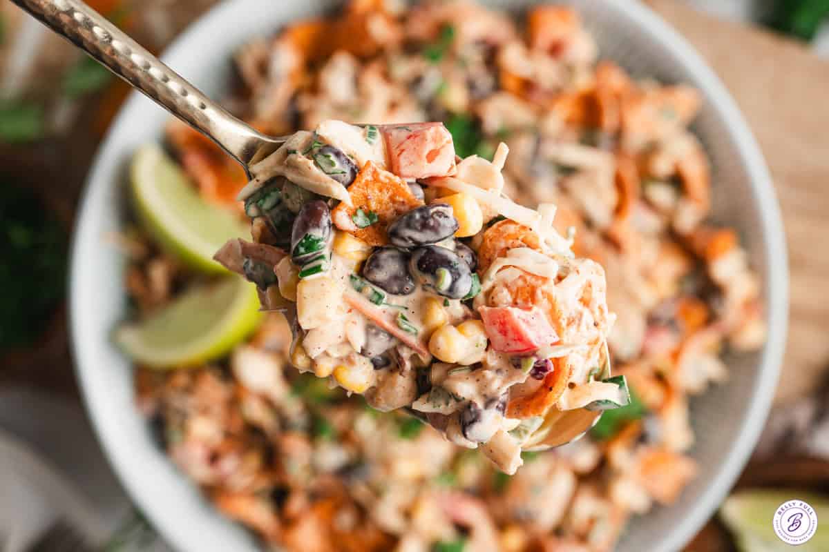 Overhead view of a bowl of cowboy coleslaw with some on a spoon.