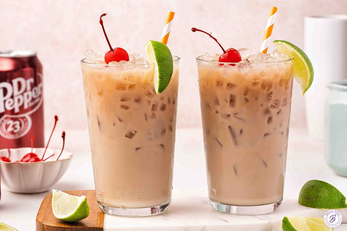 2 dirty soda drinks garnished with a lime wedge and cherry