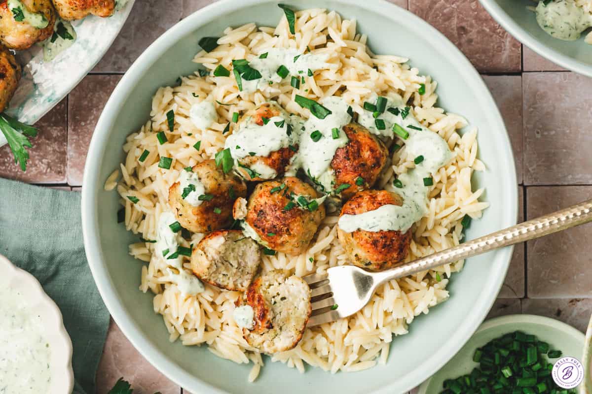 Green goddess meatballs on a plate with cooked orzo.