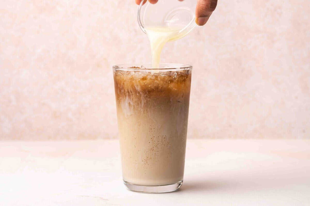 Lime juice being added to a glass of dr pepper.