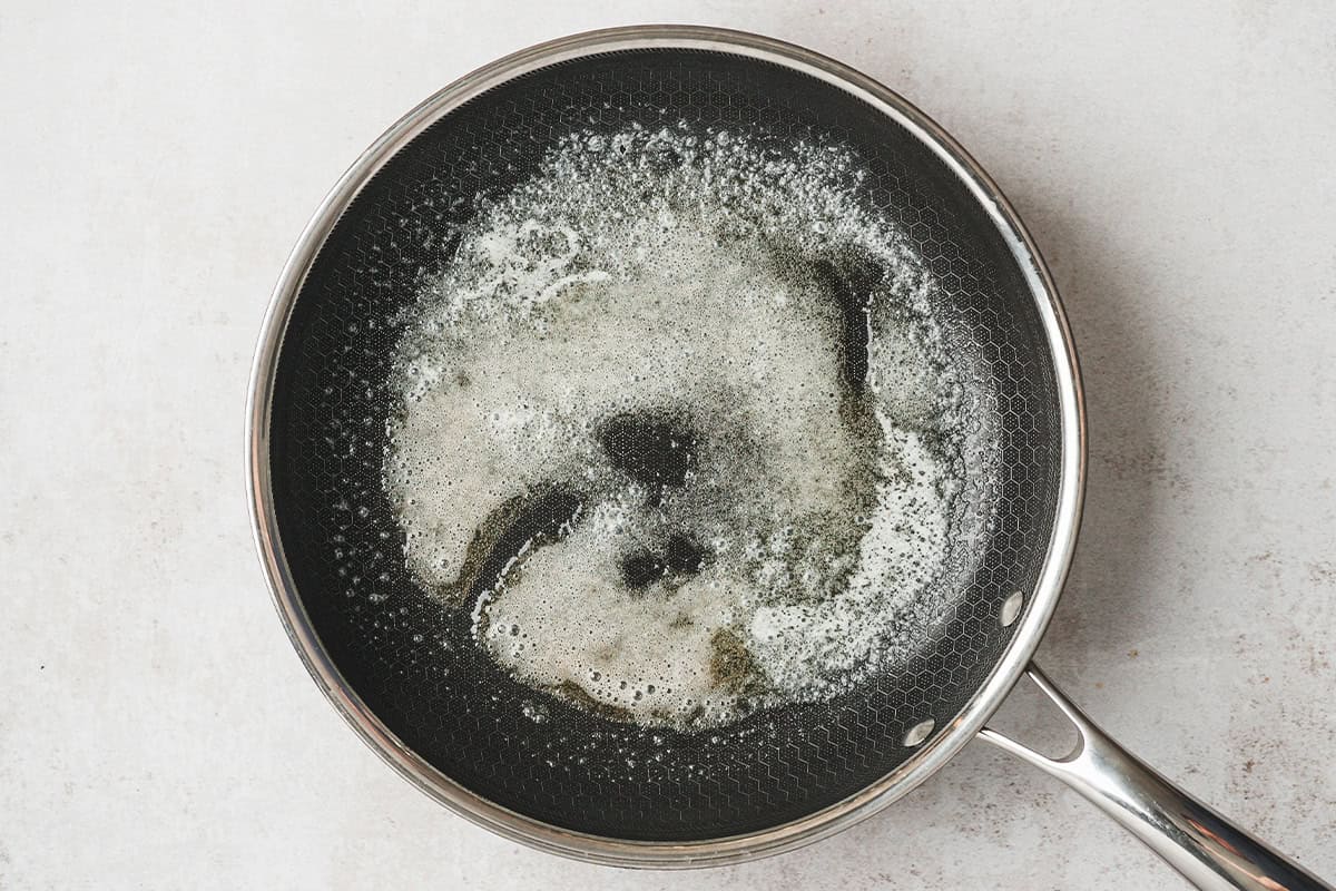 Butter foaming in a nonstick skillet before adding the eggs.