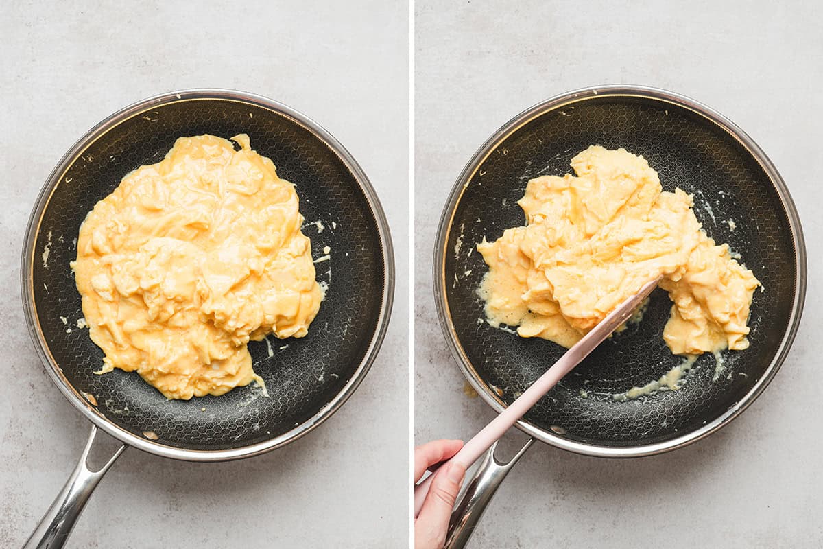 Creamy scrambled eggs forming large soft folds while finishing cooking in a skillet.