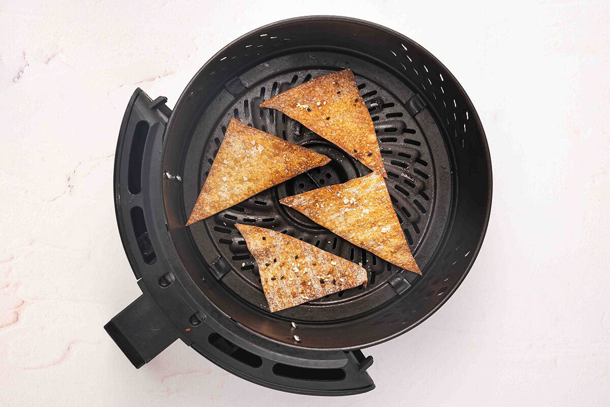 Air fryer wonton chips in an air fryer basket after cooking.