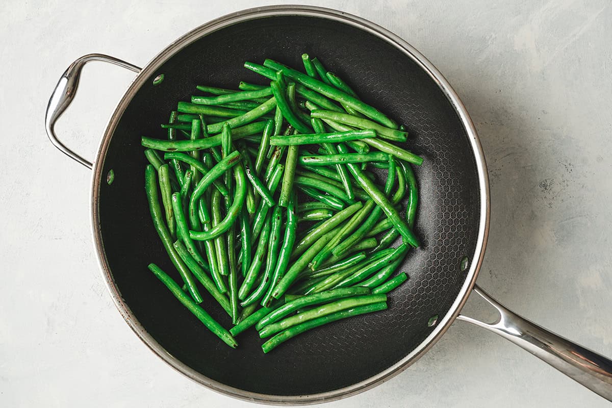 Green beans cooking in a skillet.