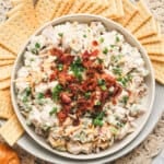 Overhead view of a bowl of million dollar chicken salad with crackers.