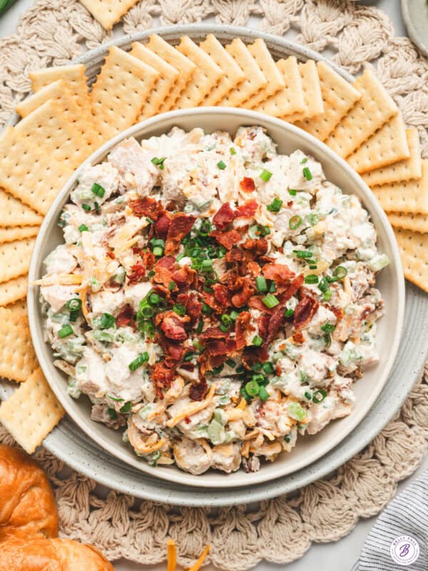 Overhead view of a bowl of million dollar chicken salad with crackers.