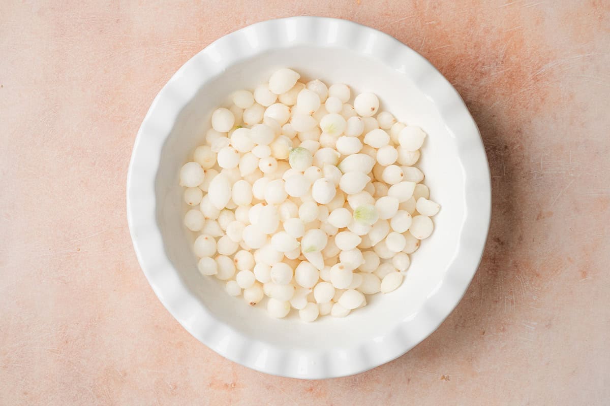 Pearl onions in a pie dish.