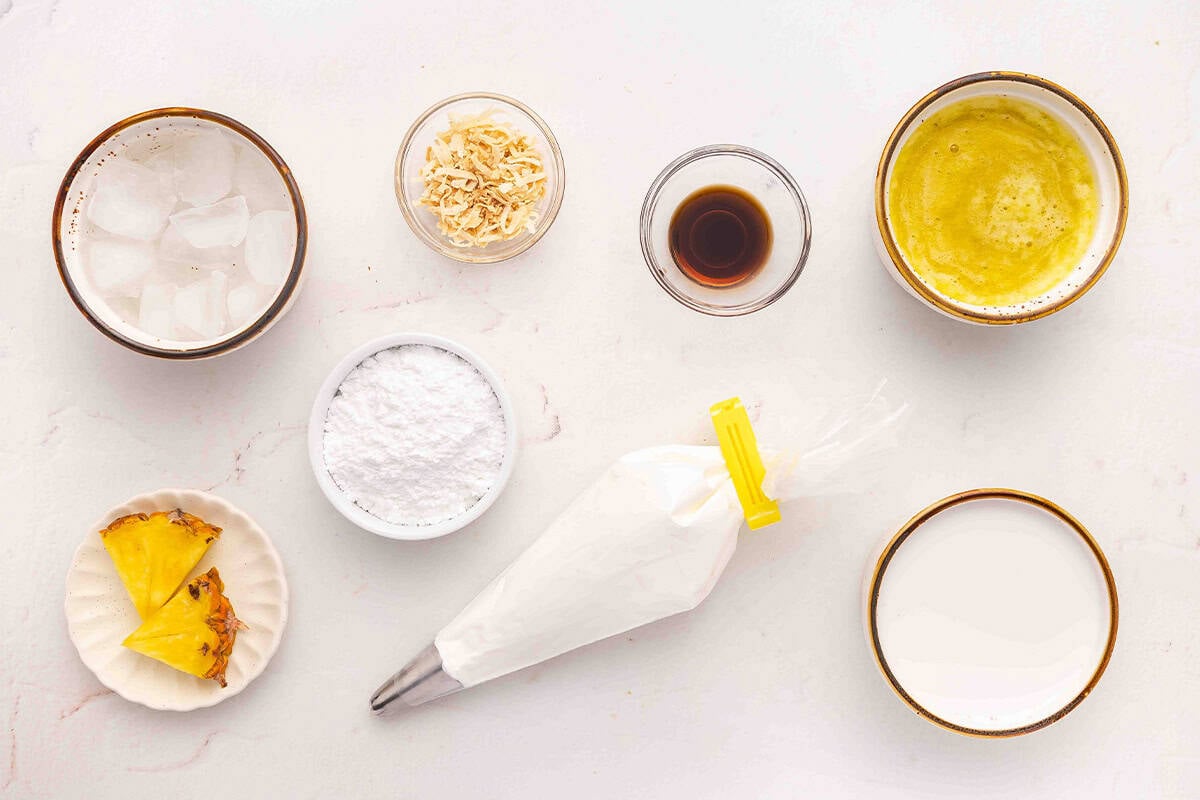 The ingredients to make a pineapple coconut orange julius drink.