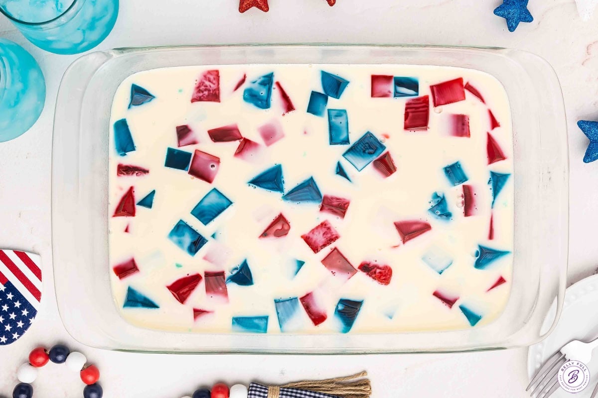 Red white and blue jello in a glass container before chilling.