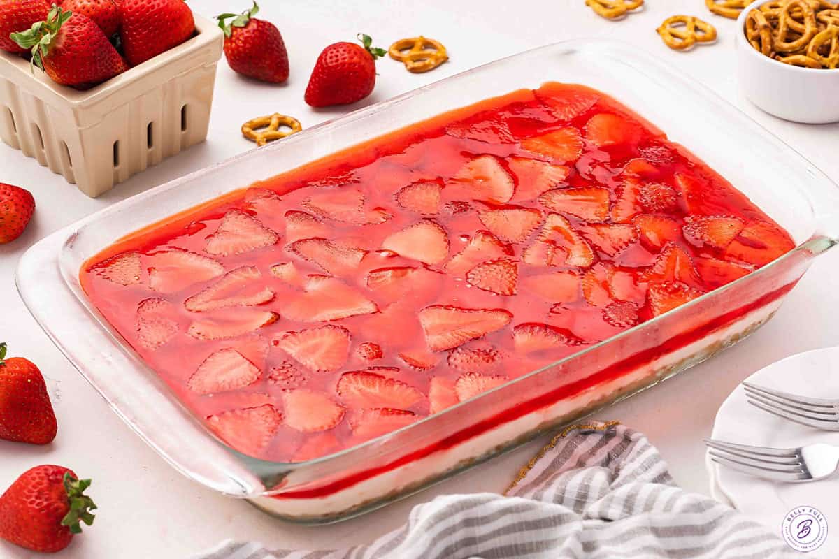 Side view of a homemade strawberry pretzel salad in a baking dish.