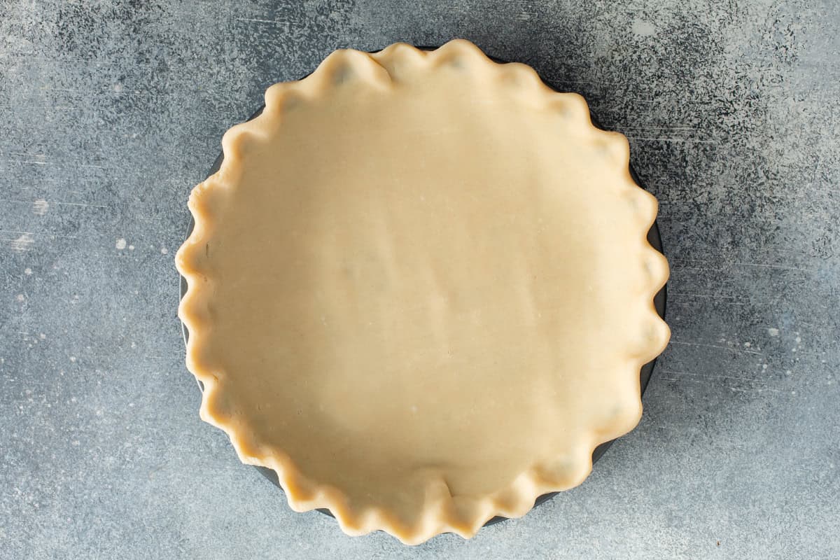 Unbaked pie crust fitted into a 9-inch pie plate with fluted edges.