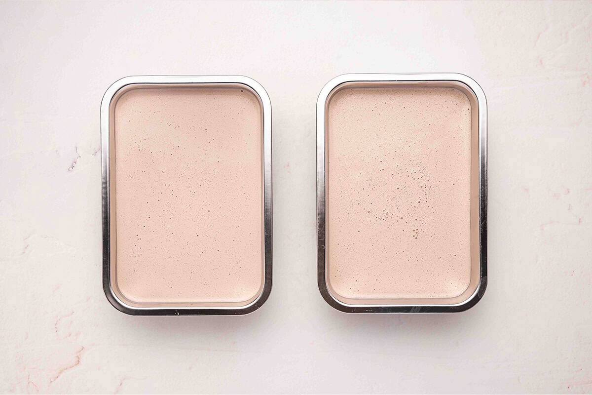 Blended Wendy's Frosty mixture divided into two stainless steel freezer containers ready to freeze