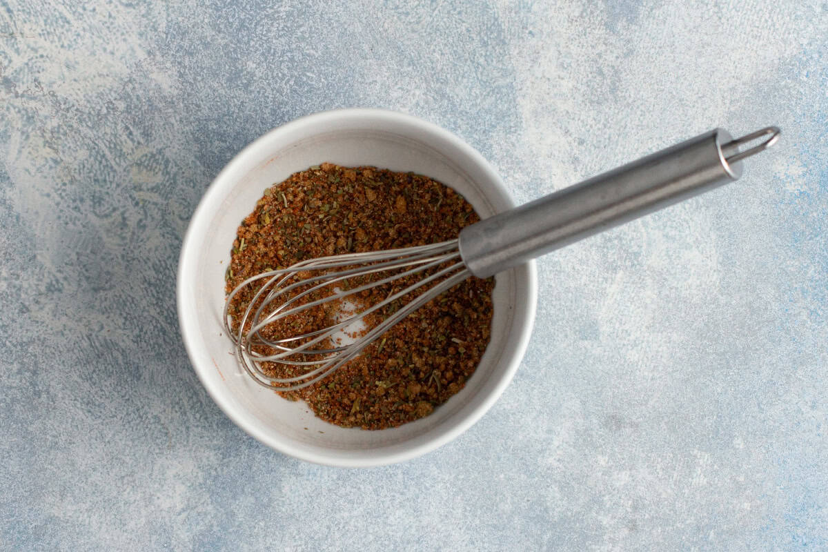 chicken seasoning mixture with brown sugar and spices in a bowl with a whisk