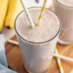 coffee banana smoothie in glass with yellow striped straw
