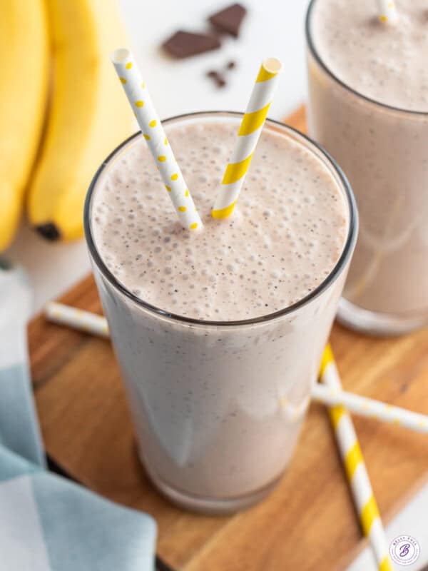 coffee banana smoothie in glass with yellow striped straw