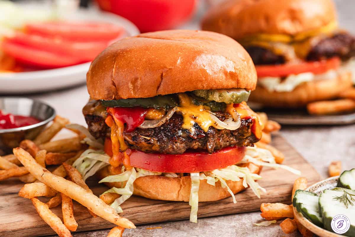 Side view of a crack smash burger with fries.
