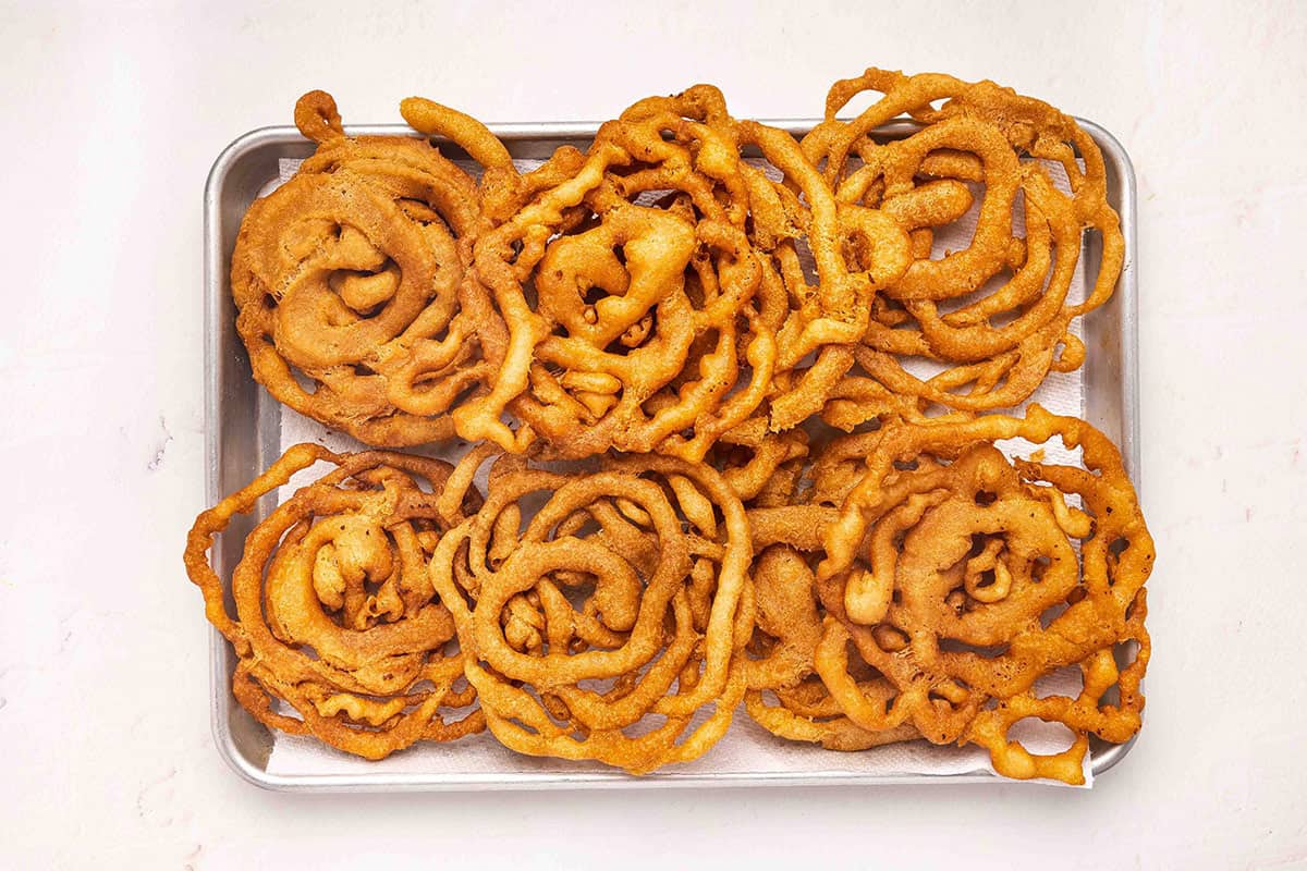 Funnel cakes on a baking sheet.