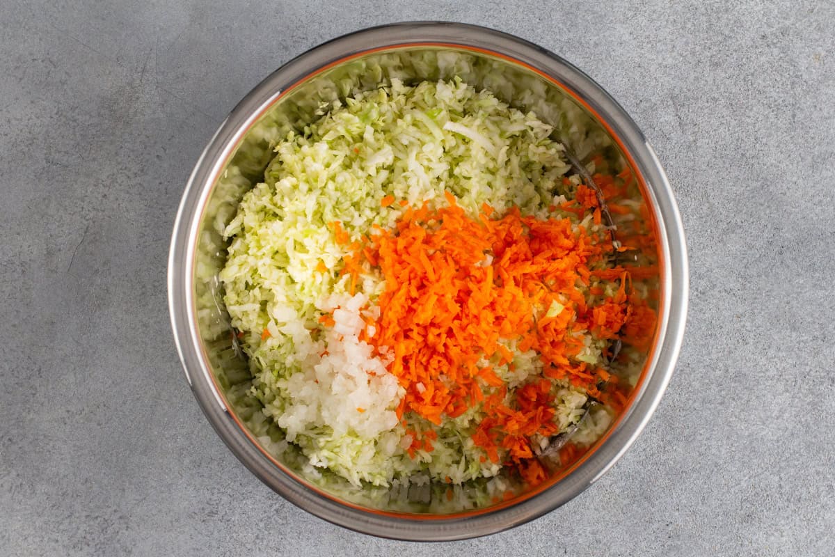 finely shredded cabbage, carrot, and onion in a bowl before mixing